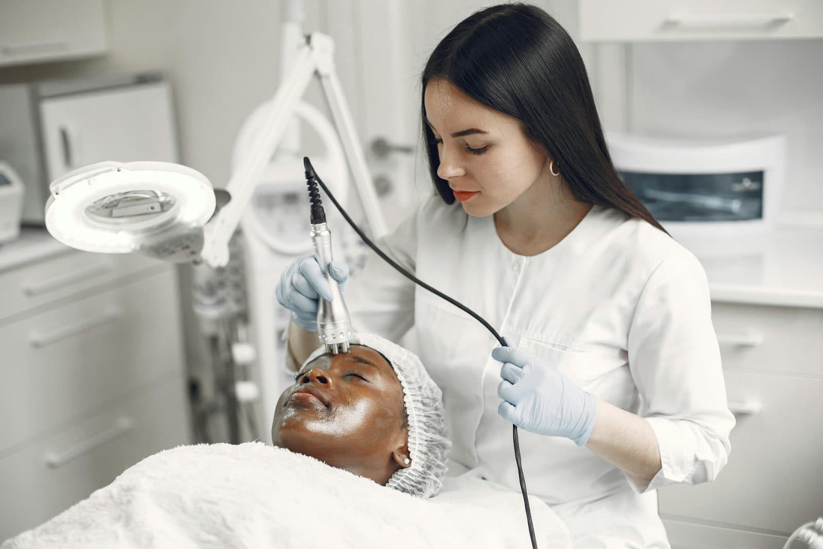 A practitioner assessing a client's skin during a consultation