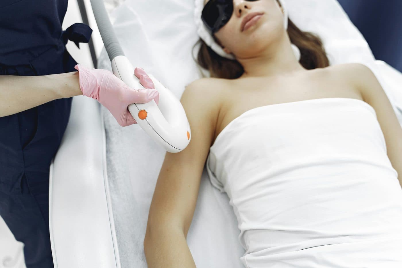 Laser hair removal being performed on a client's arm